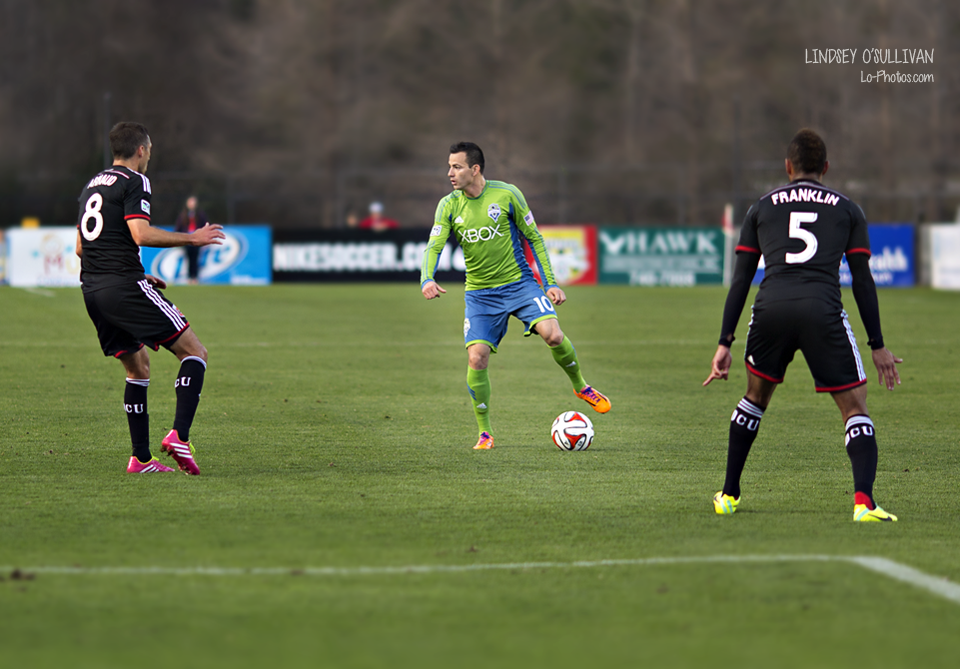Sideline view of a Seattle Sounders soccer match against DC United.