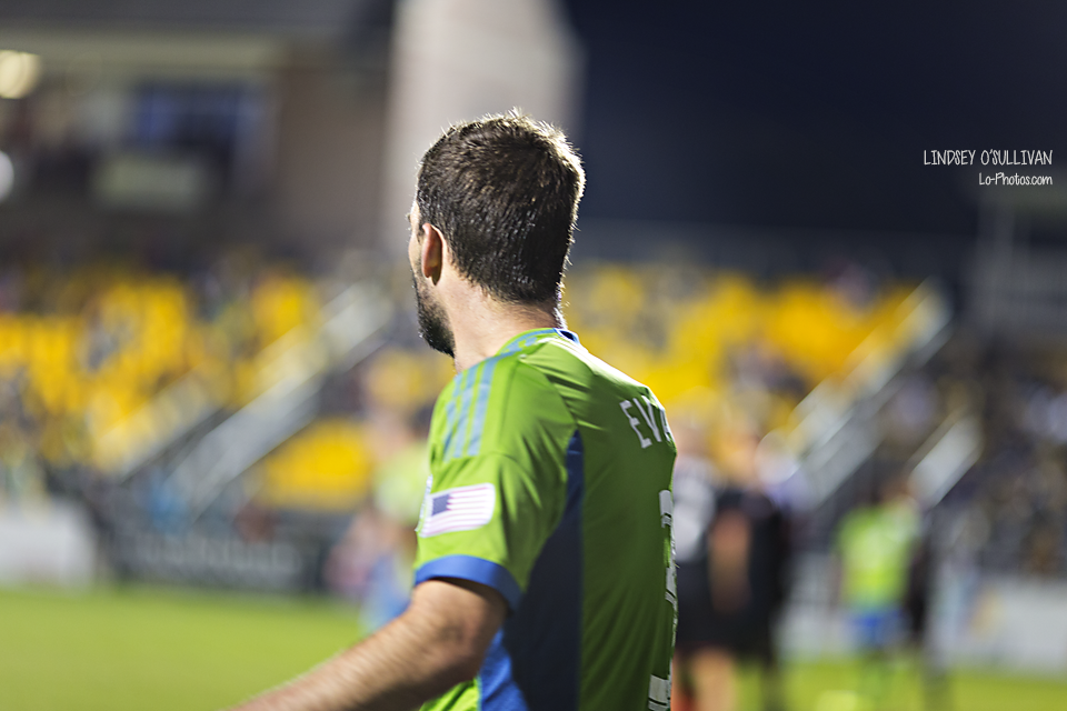 Sports photography of a soccer tackle during a Sounders match.