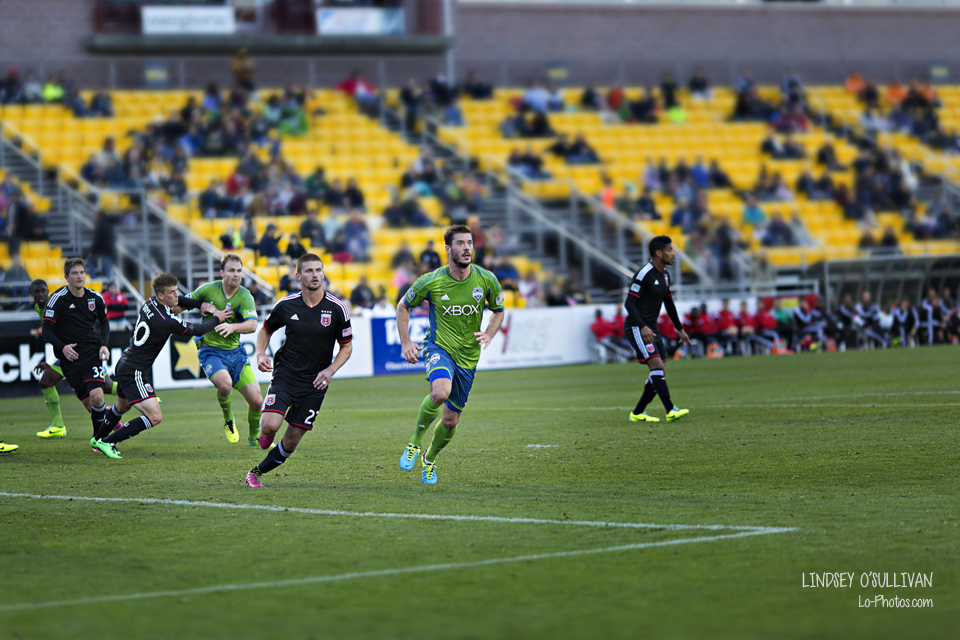 Sideline view of a Seattle Sounders soccer match against DC United.