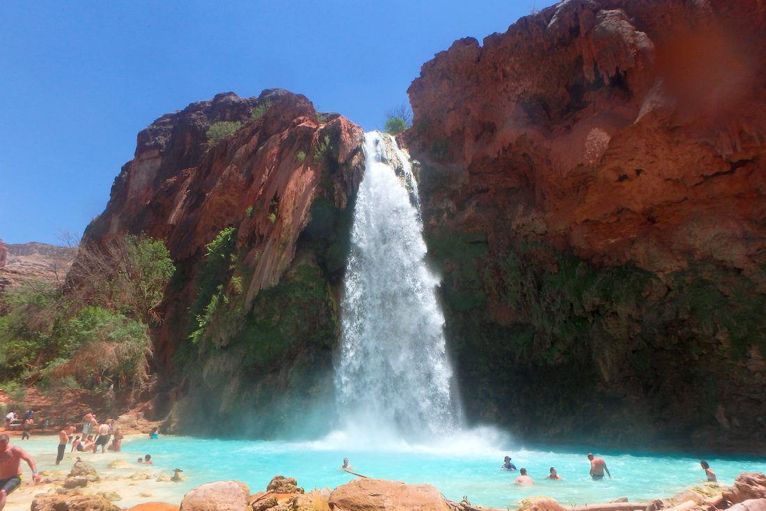 Turquoise water of Havasu Falls pouring over red rock in Arizona