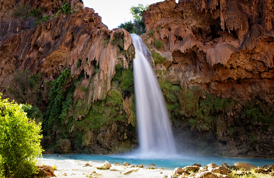 Turquoise waterfall cascading through the red rock canyon of Havasupai, Arizona