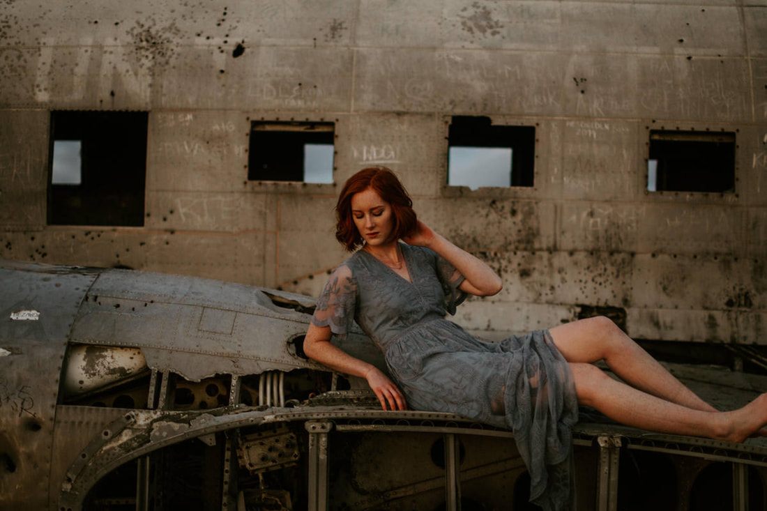 Lindsay sitting on the wing of the abandoned plane wreck in Iceland