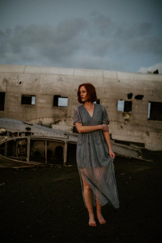 Lindsay standing alone beside the plane wreck in the vast Icelandic landscape