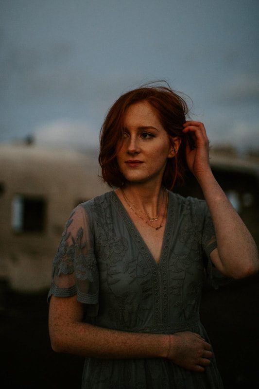 Wide shot of Lindsay dwarfed by the scale of the abandoned plane wreck