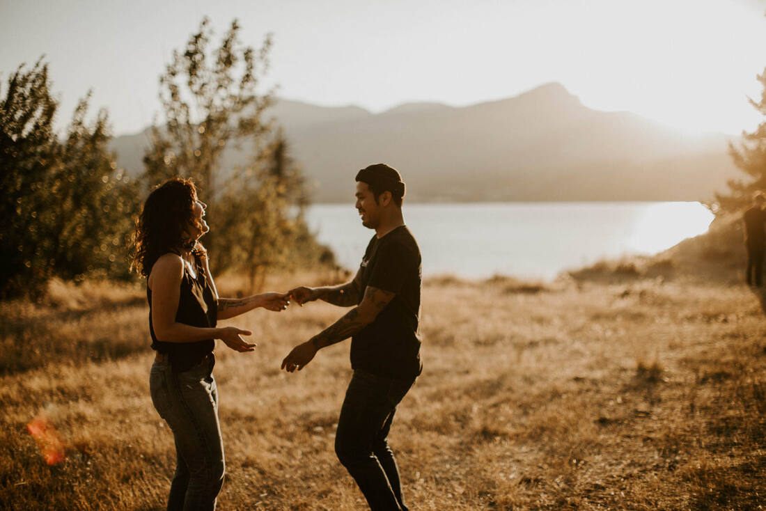Candid portrait of the couple laughing together outdoors, later in the golden hour session