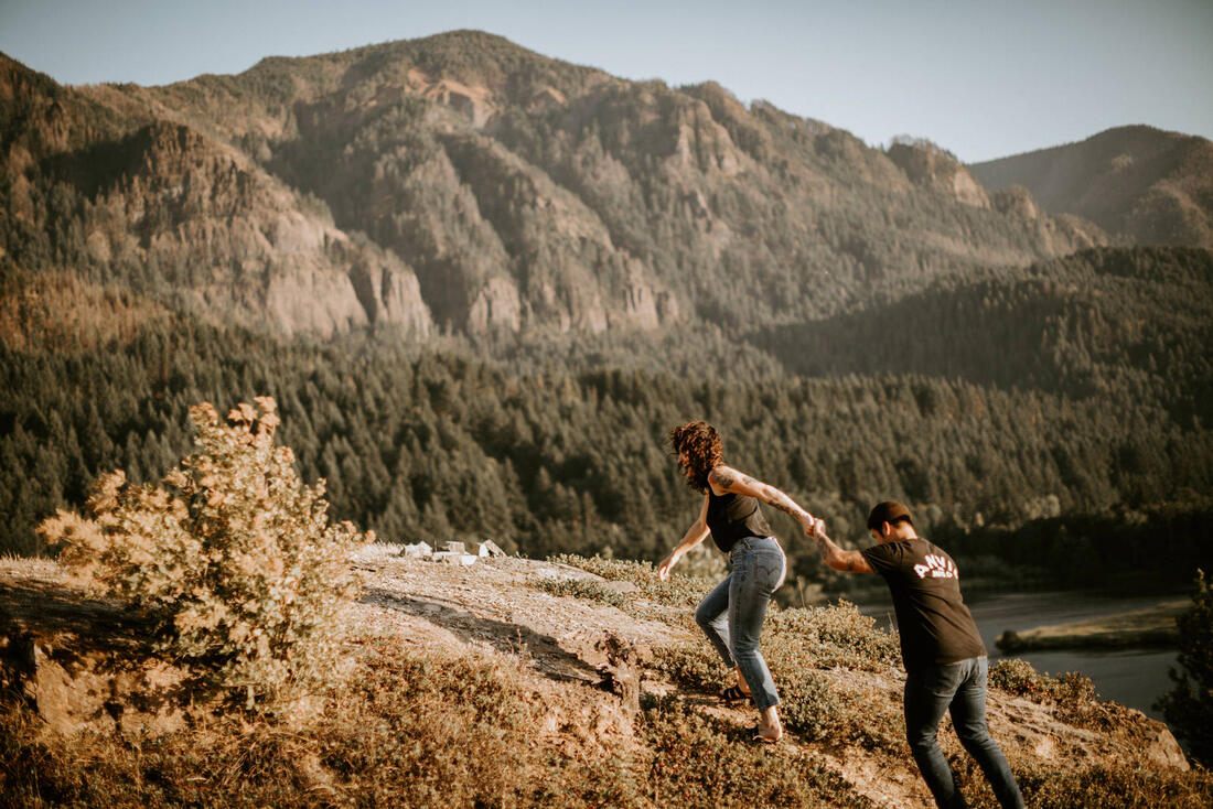 The couple sitting close together taking in the mountain view, later in the golden hour session