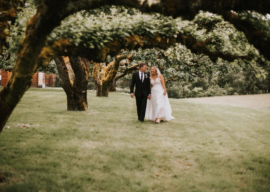 Outdoor wedding ceremony beneath cherry trees at The Orchard at Sunshine Hill in Chehalis, WA.
