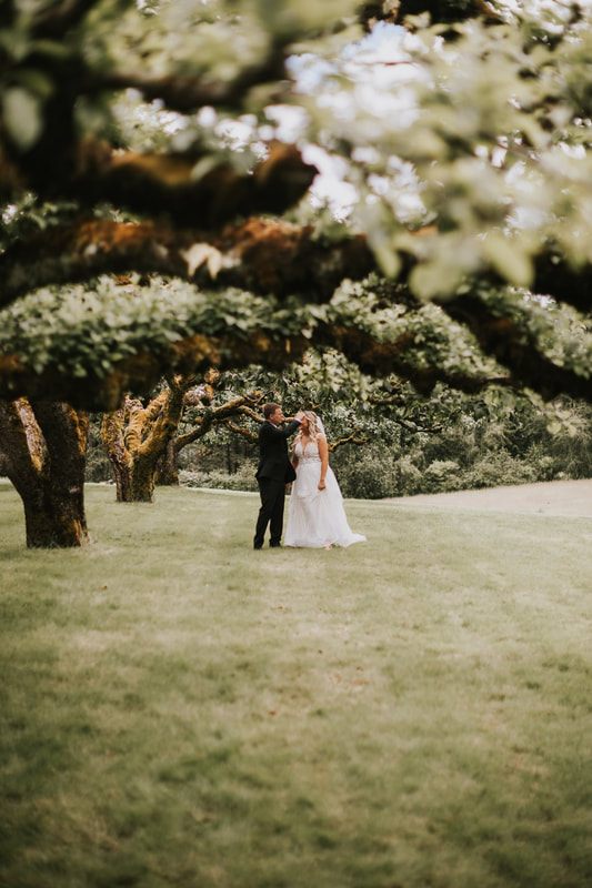 Bride and groom sharing a first look among blossoming cherry trees at Sunshine Hill.