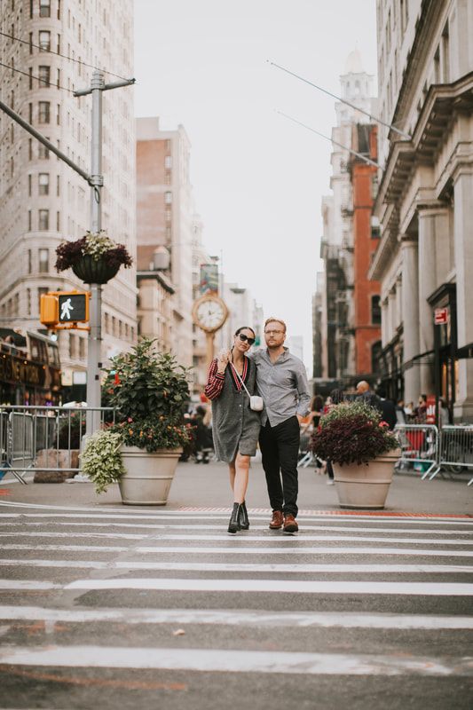 Karina and Matt walking near the Flatiron Building during their NYC engagement session