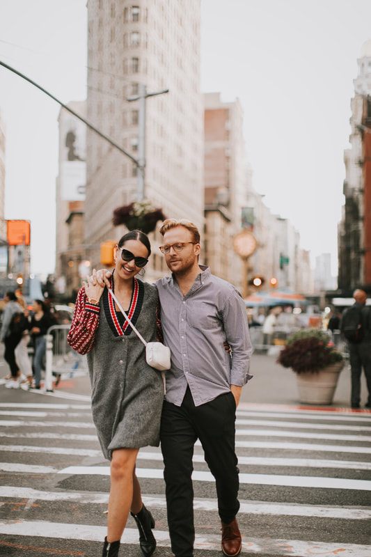 Couple laughing together on a New York City street during their engagement photos