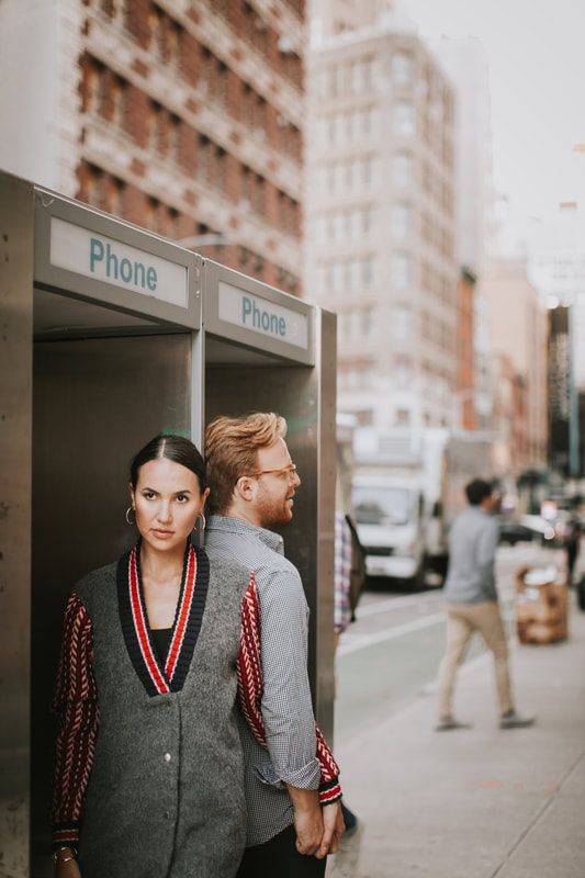 Couple embracing under city scaffolding during their engagement session