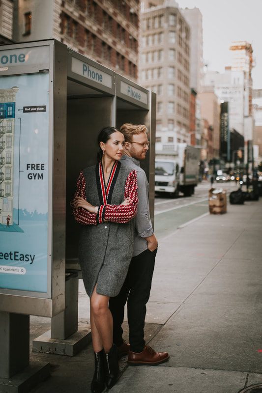 Close-up engagement portrait with the energy of the city behind them
