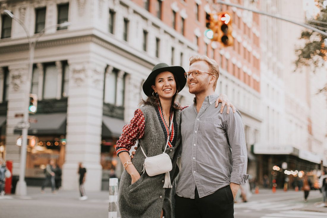 Karina and Matt walking together near the Flatiron Building at dusk