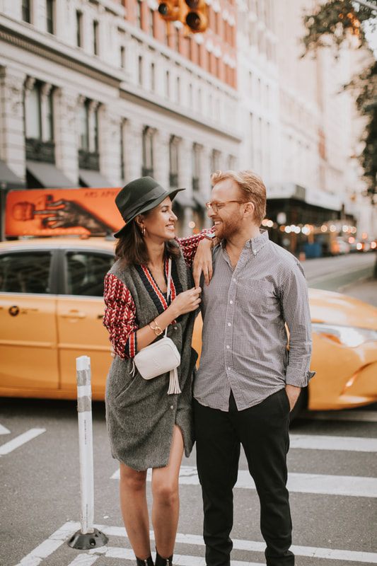 Couple posing together as city lights begin to turn on around them