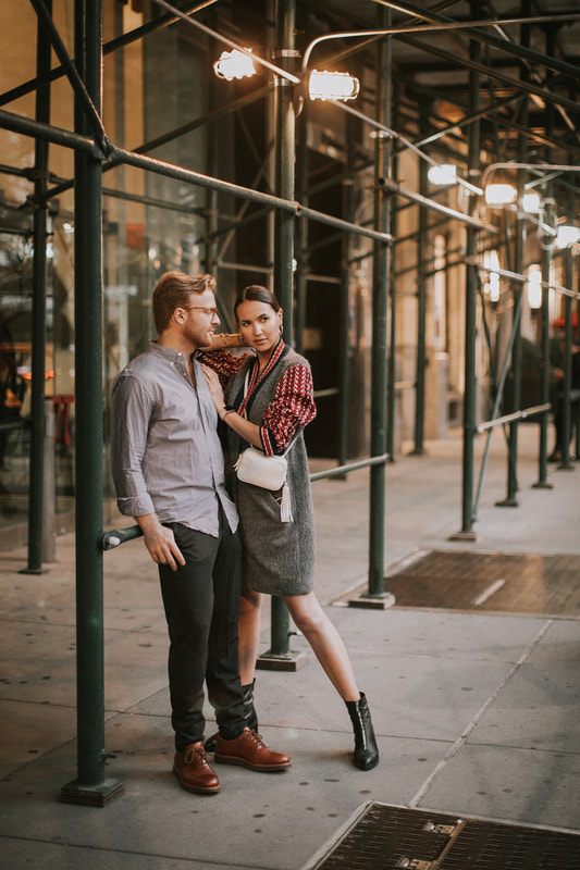 Couple walking hand in hand as evening falls over New York City