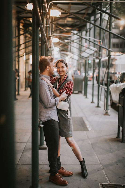 Karina and Matt sharing an embrace under city lights