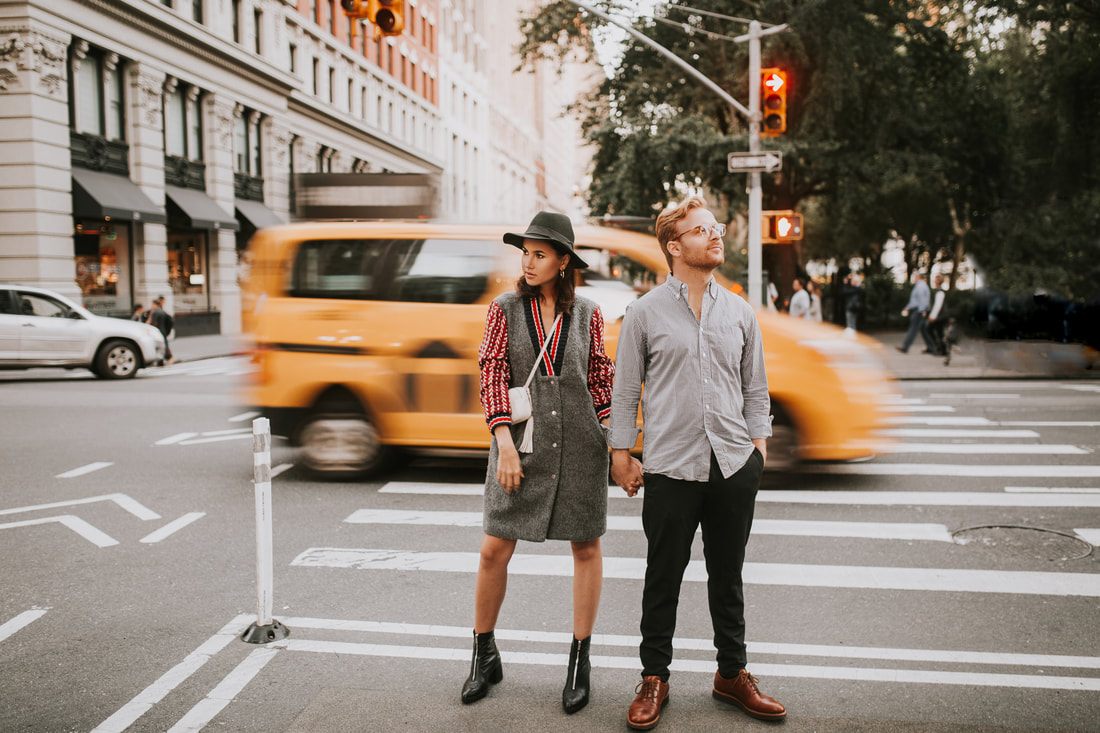 Engagement session portrait with the city skyline glowing behind them
