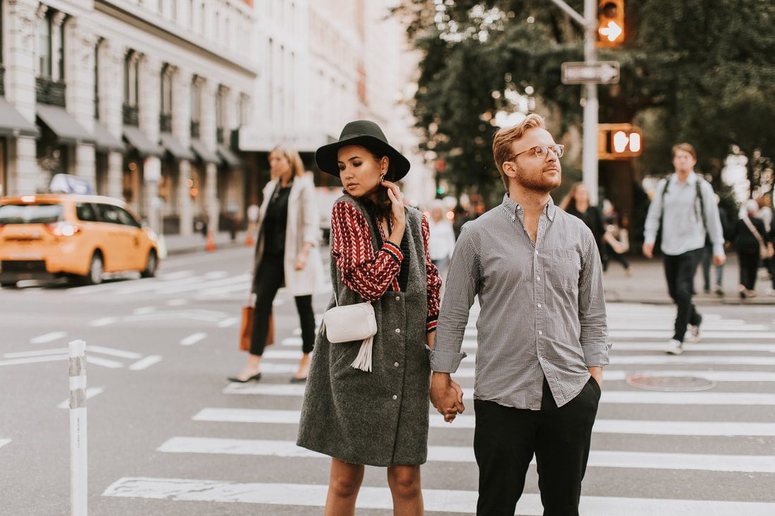 Couple posing together near a New York City intersection at night