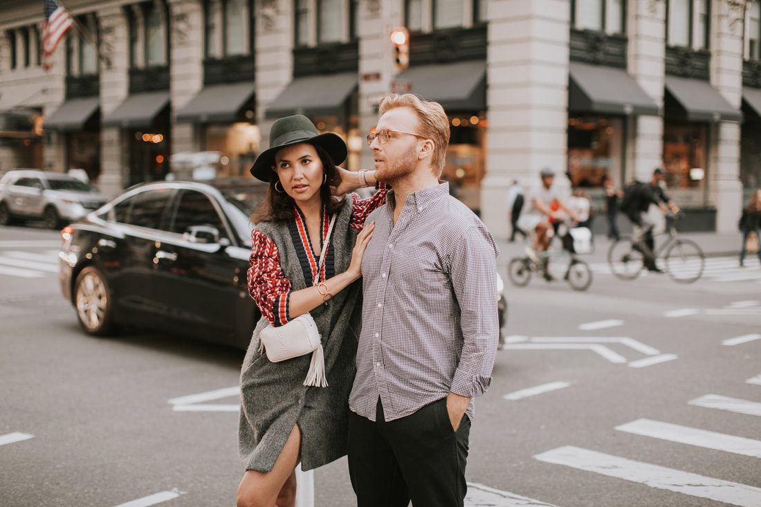 Candid portrait of the couple laughing on a busy sidewalk