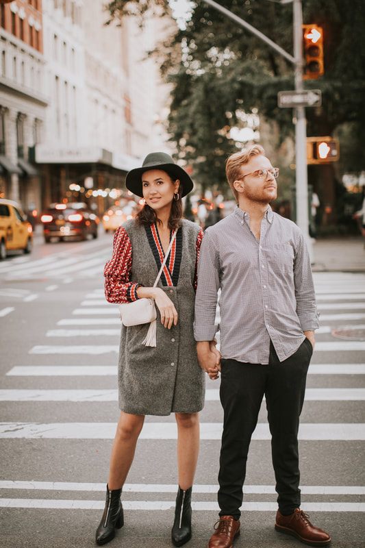 Karina and Matt embracing as the city glows around them at dusk