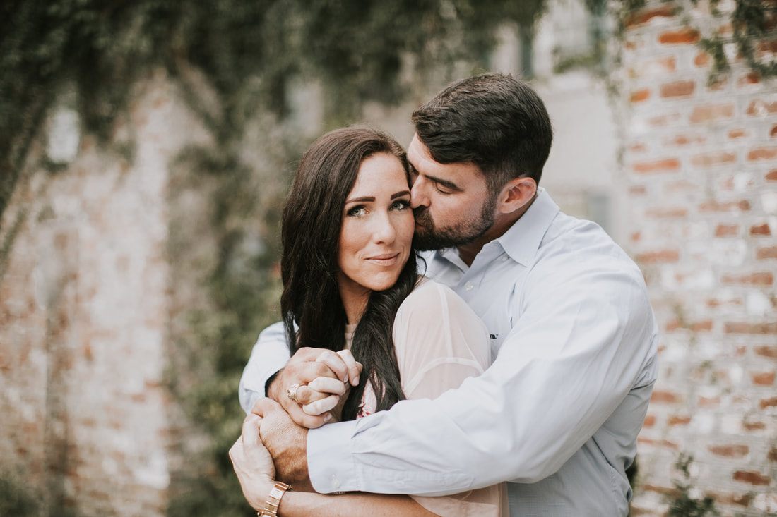 Anna and Clint dancing together in a downtown Charleston alley with exposed brick