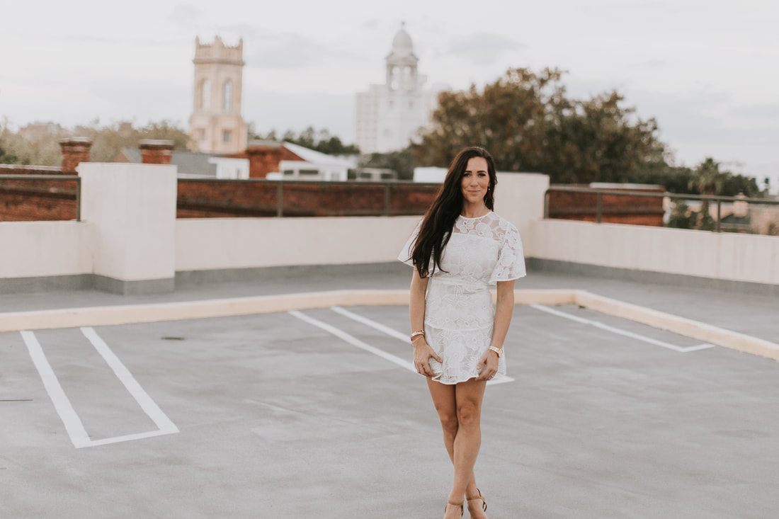 Anna pausing for a candid portrait with a view of the Charleston skyline