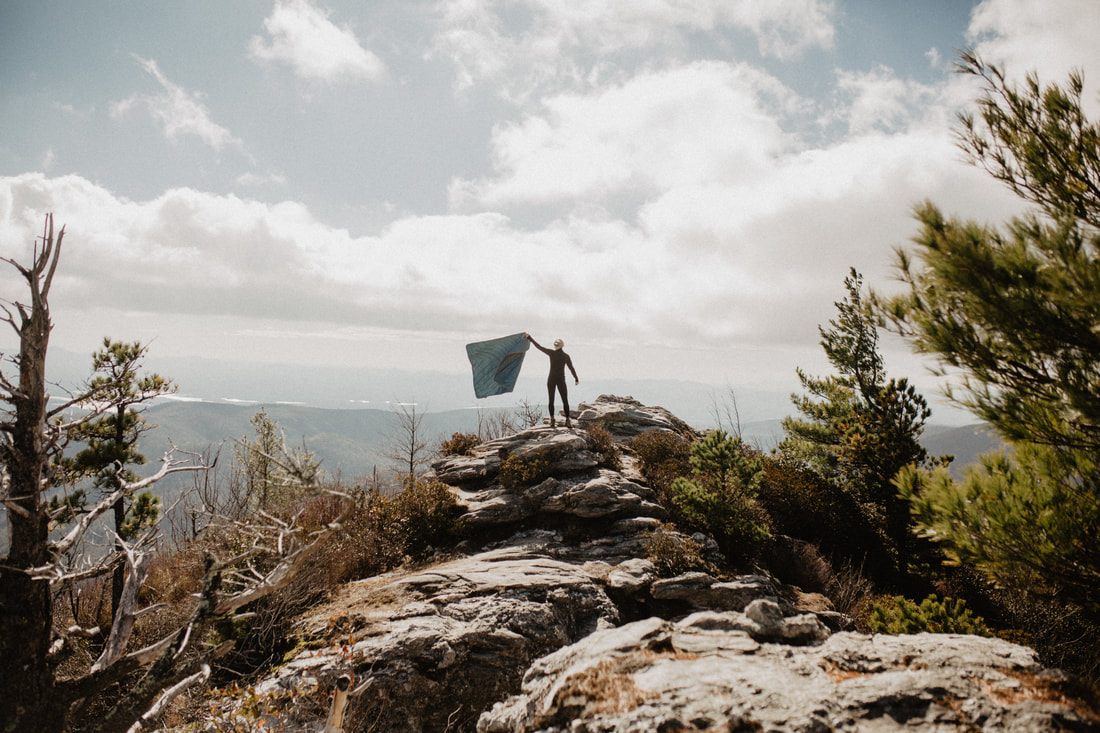 Lifestyle photo of a Rumpl blanket used during a road trip stop in nature.