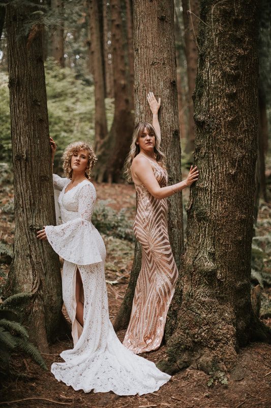 Two women in evening gowns walking along a wooded Kirkland trail
