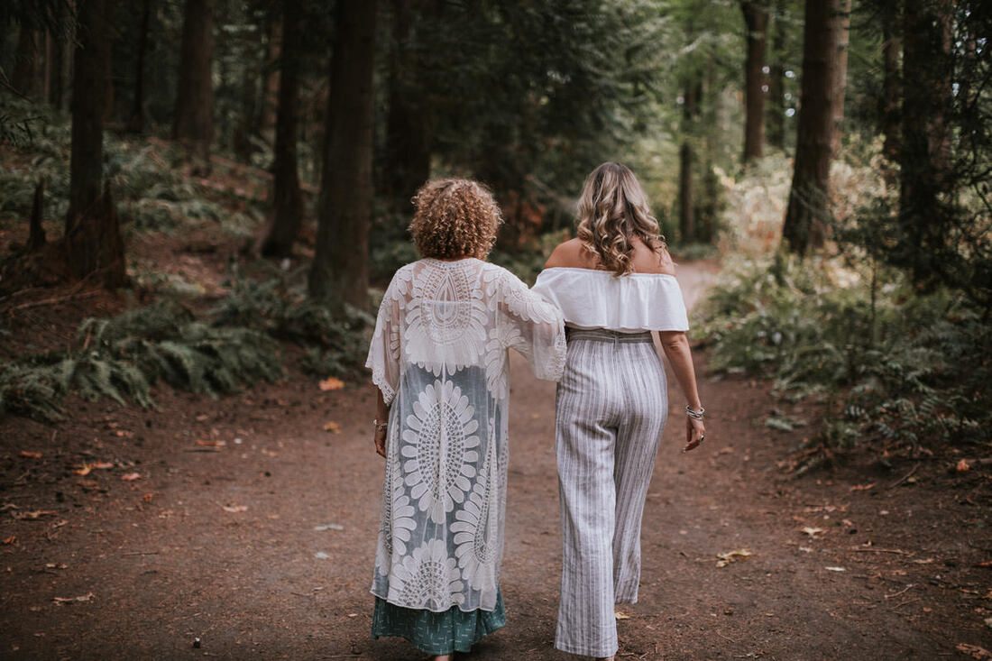 Savannah and Amanda posing together against a backdrop of PNW greenery