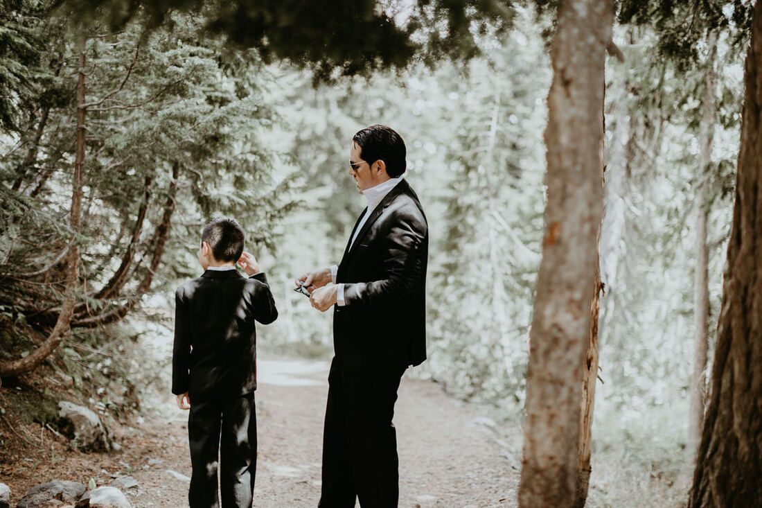 Bride's ivory gown catching the light against dark trees at Mt. Rainier.