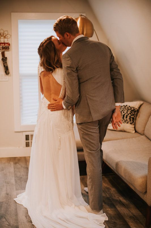 Groom helping his bride down a forest trail during their elopement