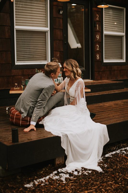 Couple sitting together on the cabin porch during golden hour