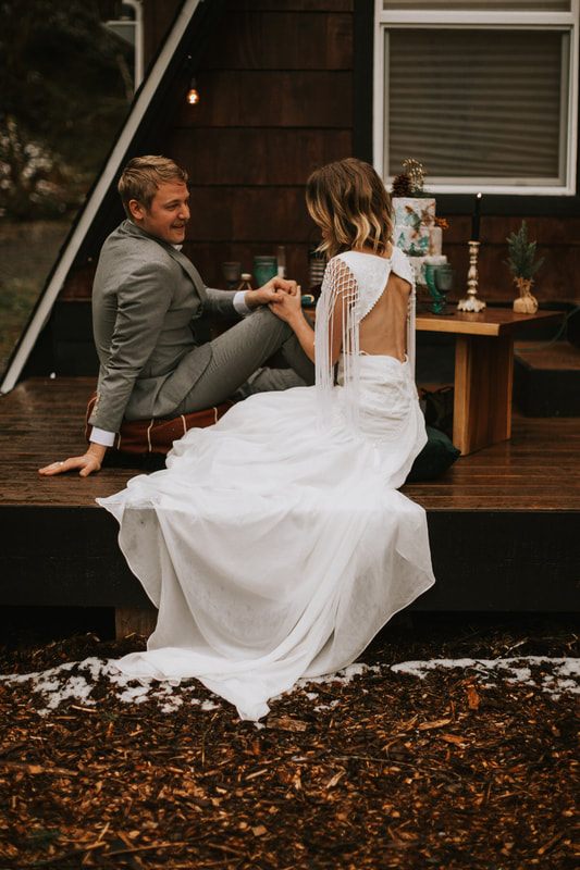 Bride and groom embracing near the creek behind the cabin