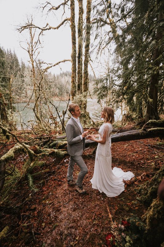 Wide shot of the couple standing at the edge of the forest clearing