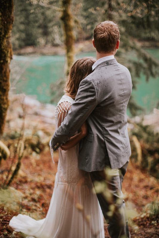 Bride and groom laughing together on the forest trail
