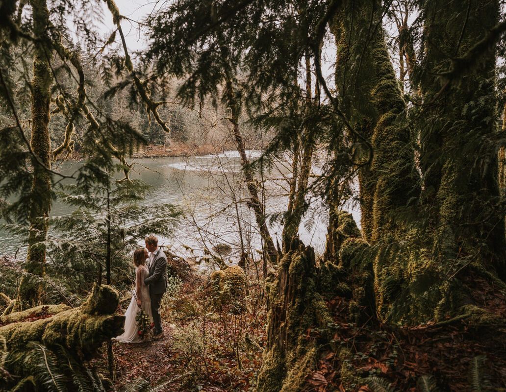 Couple standing together as evening light filters through the trees