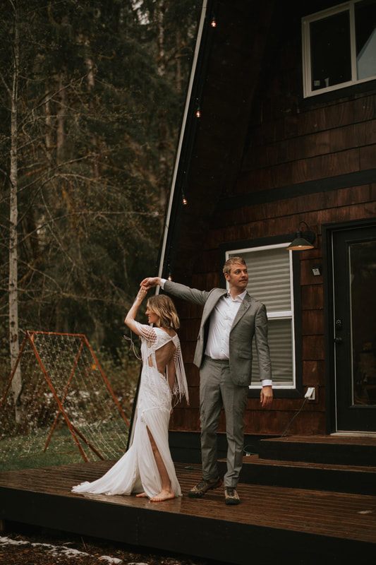Couple hiking through moss-covered trees near their elopement cabin
