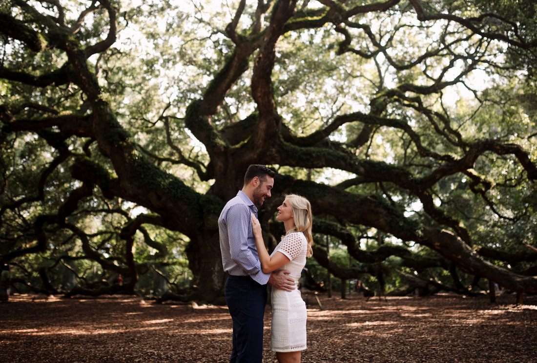 Andrew and Kelly standing beneath sprawling oak branches at the Angel Oak Tree on Johns Island