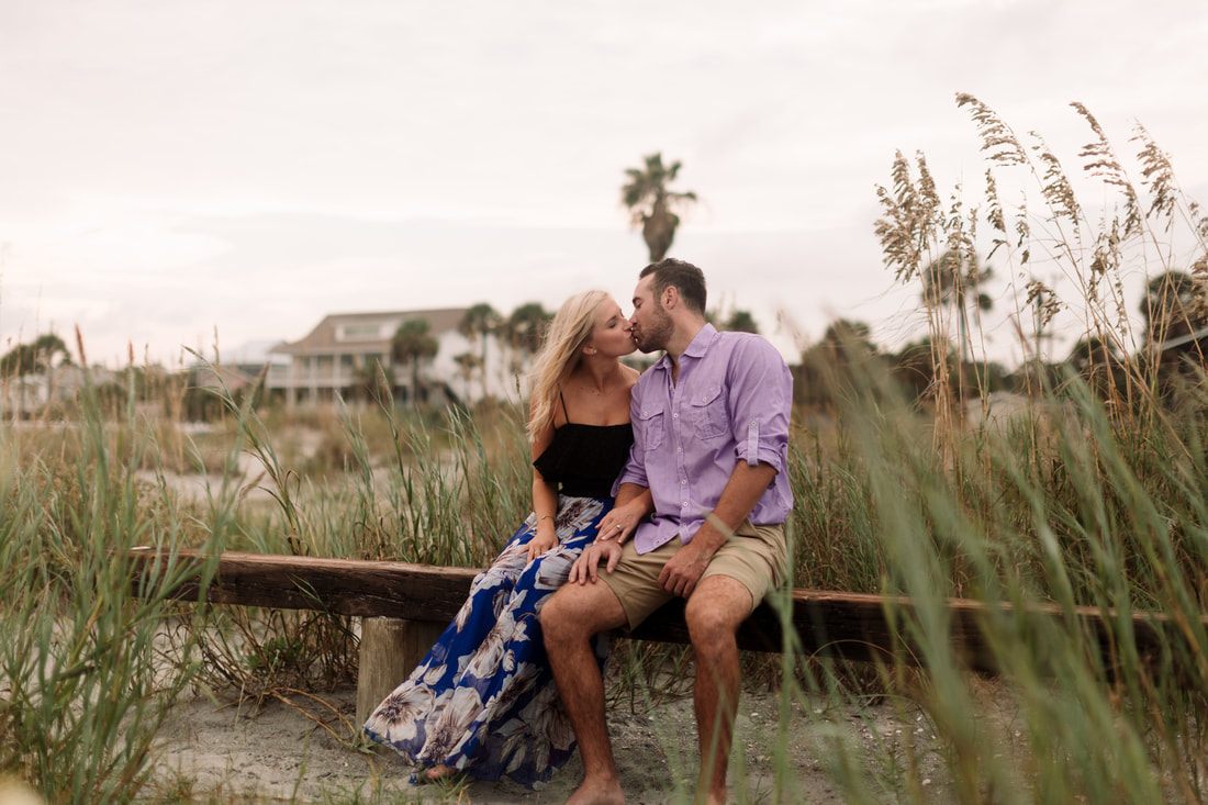 The engaged couple posing beside ancient oak limbs on a rural stretch of Johns Island