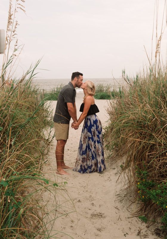 The couple standing beneath sprawling oak branches along a quiet Lowcountry road