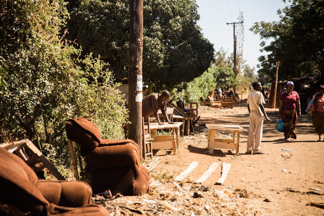 Handwoven baskets and secondhand goods for sale at a Zambian street market