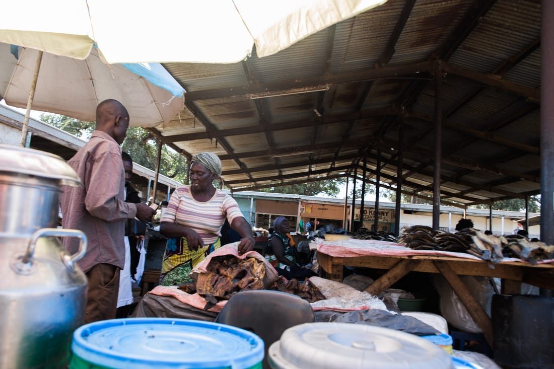 Handwoven baskets and secondhand goods for sale at a Zambian street market