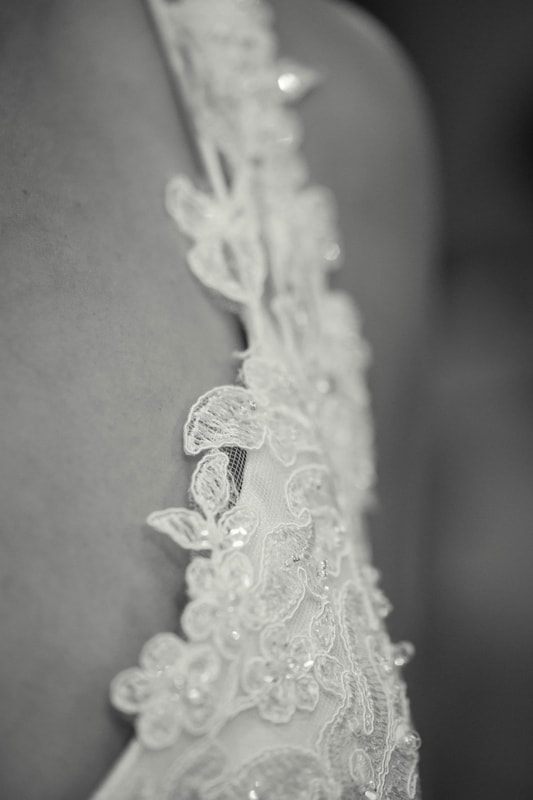 Detail shot of the wedding rings resting on a garden bench