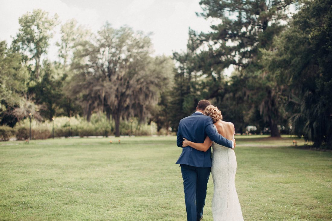 Ashley and Madison sharing a candid laugh during their Charleston wedding at Magnolia Plantation