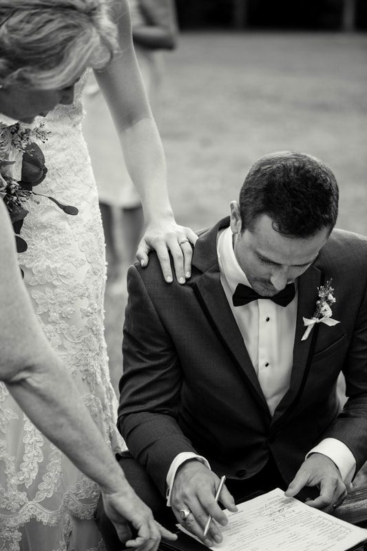 Groom wiping away tears as he watches his bride approach