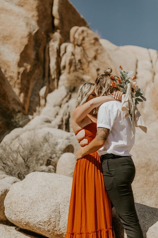 Close-up portrait of Ciarra and AJ smiling in the California desert.