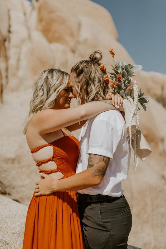 Ciarra and AJ pose together at golden hour in the desert.