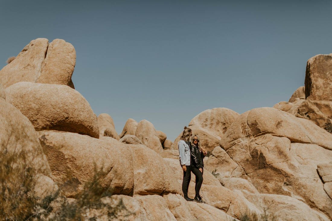 Ciarra and AJ pose together among the rock formations of Joshua Tree National Park.