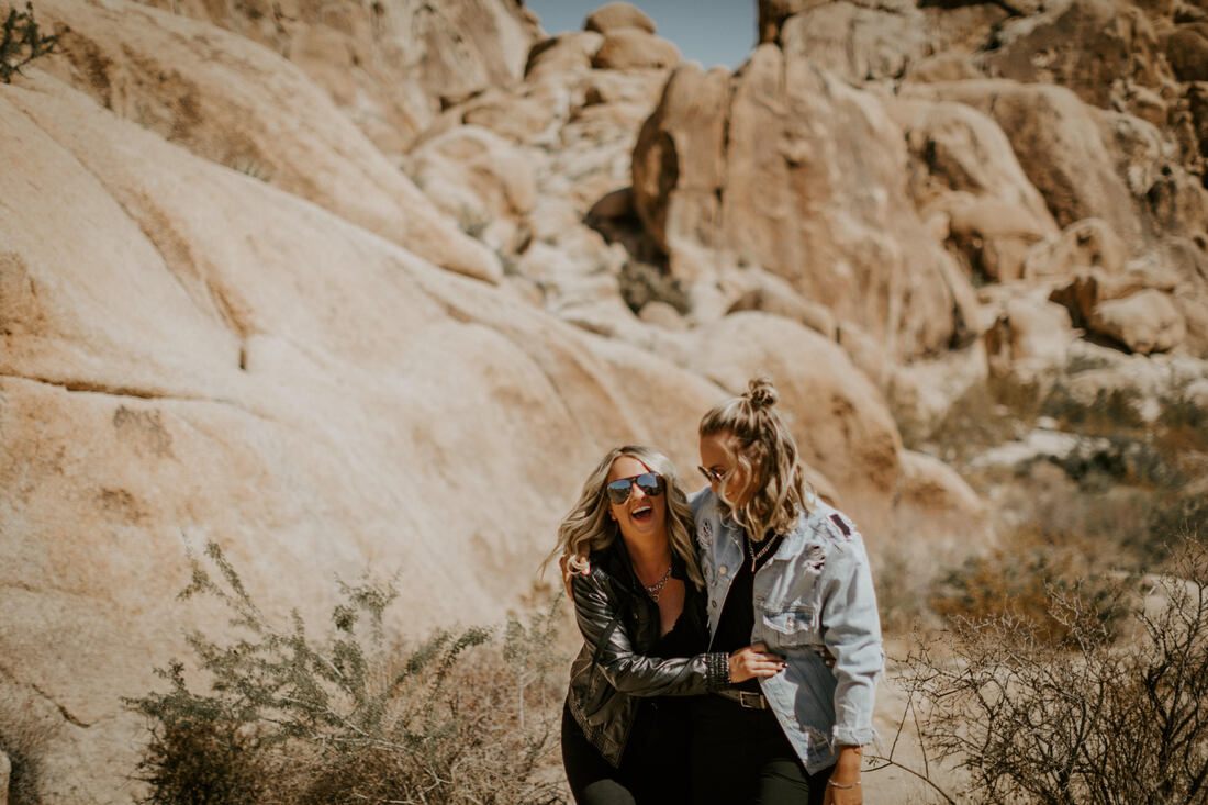 Ciarra and AJ embrace among the boulders of Joshua Tree National Park.