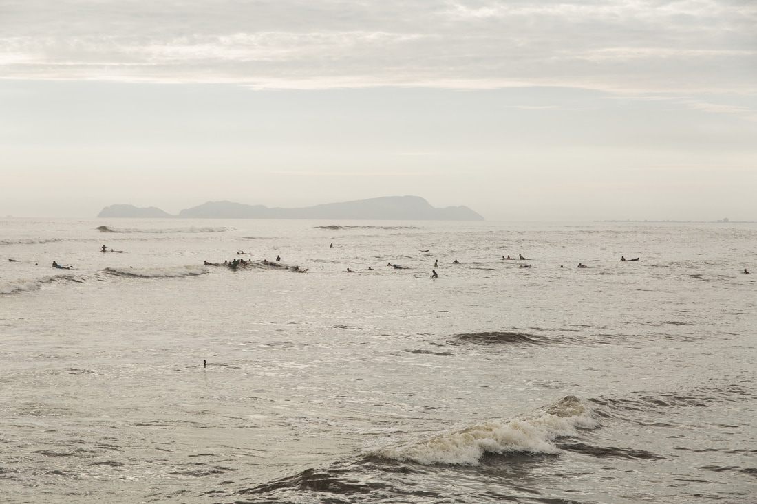 Surfers along the Pacific coastline near Miraflores, Lima